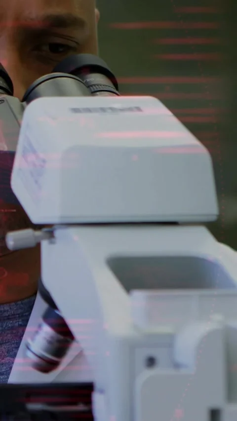 Vertical video: Lab tech peering scope as python code growing, causing UI Stock Footage 330510002