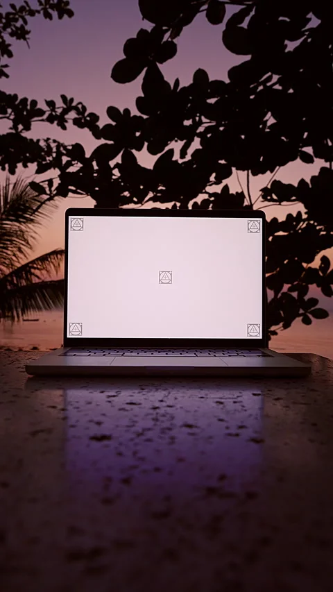 Vertical video. Laptop With Blank Screen On Stone Table Against Tropical Sunset Stock Footage 332307256
