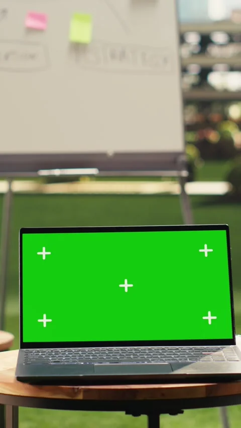 Vertical Video Laptop green screen on table in clean empty rooftop office Stock Footage 339069743