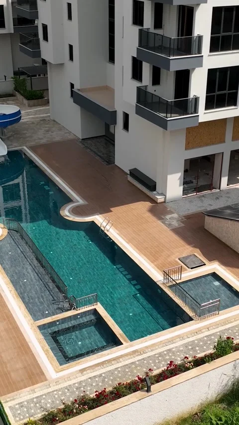 Vertical Video: Large Pool with Playful Kids Sliding Down Bright Water Slides on Stock Footage 297713245