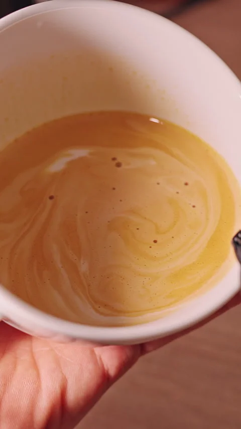 Vertical video. Latte Art Pattern Appearing In Fresh Coffee Cup While Milk Is Ca Stock Footage 330542336