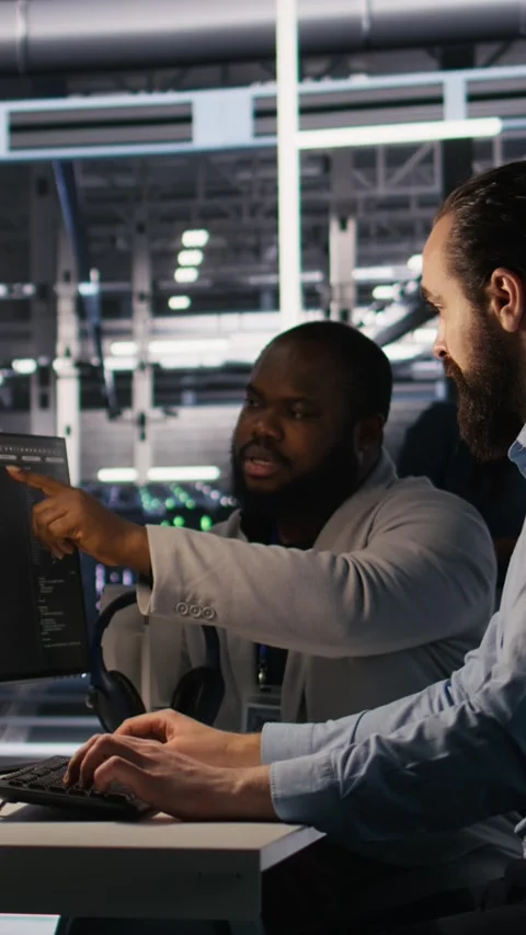 Vertical video Lead data center engineer overseeing team integrating AI Stock Footage 309256315