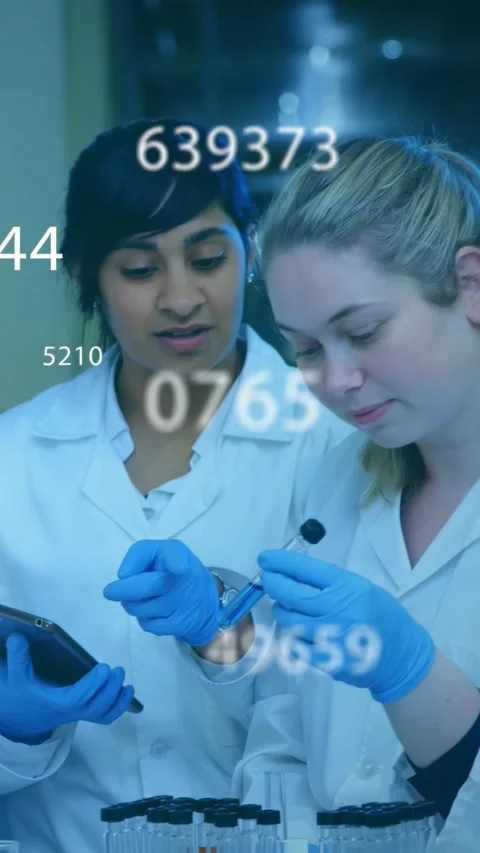 Vertical video: Lead tech checking vial sparking data overlay team viewing Video stock 330542894