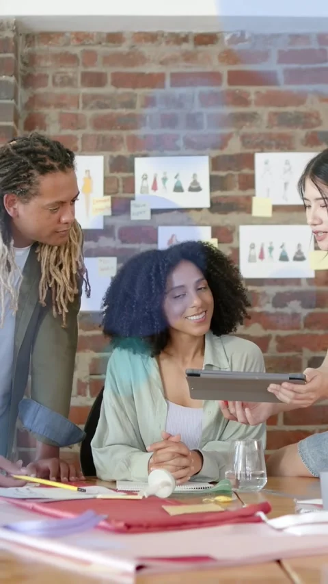 Vertical video: Lead viewing tab as peer presenting choosing fashion LEDs Stock Footage 333649793