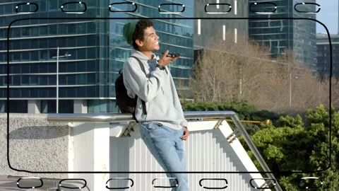 Vertical video: Leaning on railing, man speaking into smartphone on urban Stock Footage 334185591