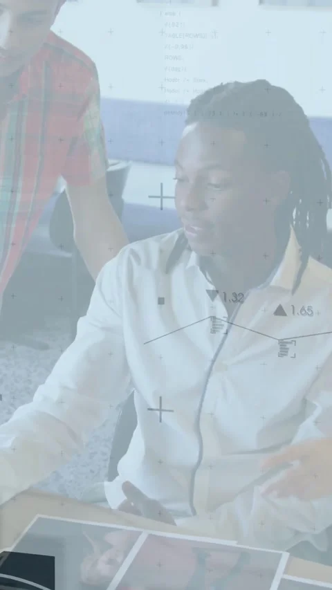 Vertical video: Left peer pointing at table starting seated reviewing IT data Stock Footage 331739310