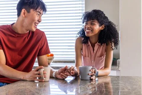 Vertical video: Light through blinds leading couple clasping hands and sharing Fotos Stock