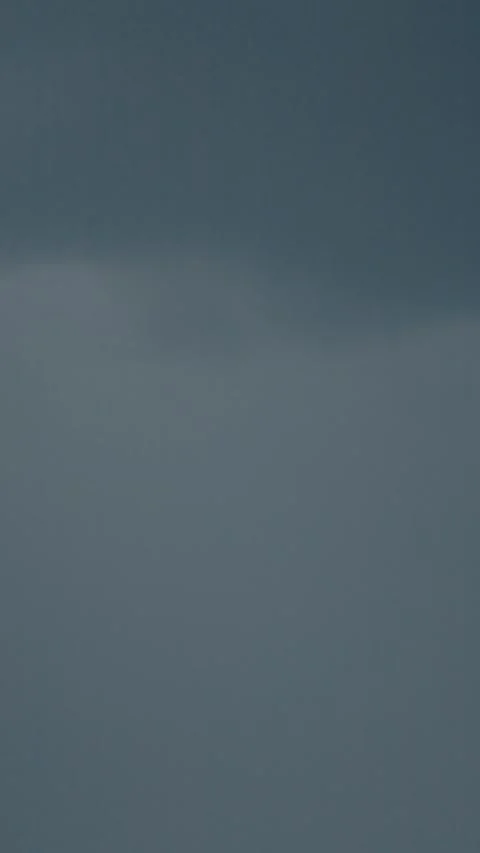 Vertical video Lightning flashes illuminate dark storm clouds in a dramatic sky Stock Footage 323353155