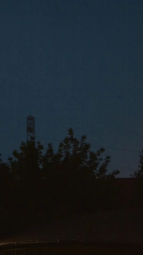 Vertical video Lightning flashes illuminate the dark sky ahead of an approaching Stock Footage 323353585