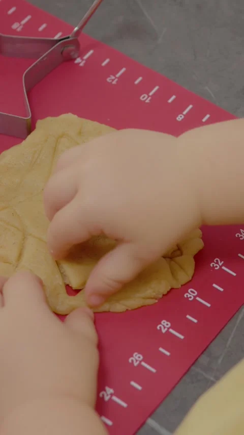 Vertical video Little boy and mother bake cookies and cut dough into fun shapes Stock Footage 329628611