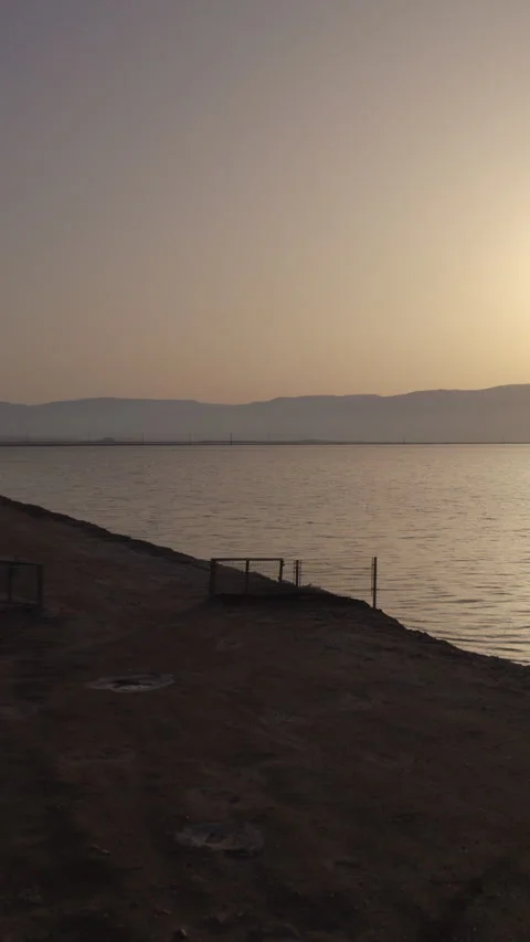 Vertical video of a lonely white trailer parked silhouette on one of the sand Stock Footage 310669976