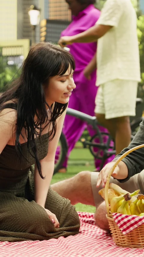 Vertical Video Loving partners fooling around with fruits from picnic basket Stock-Footage 341472452