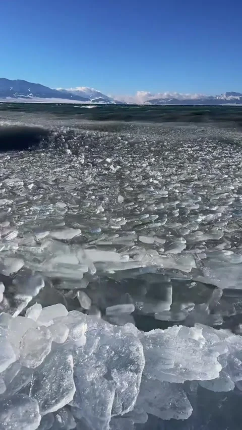 Vertical video low angle view of ice shards and slush rolling on waves at fr Stock Footage 327695088