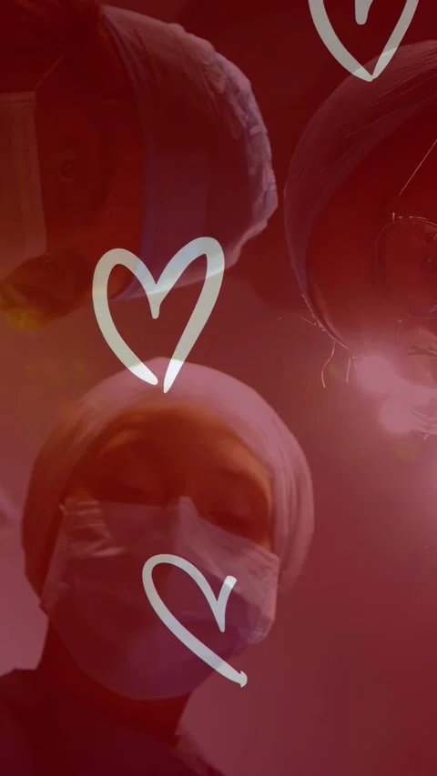 Vertical video: Low camera angle drawing med staff leaning over lens, red hearts Stock Footage 335355275