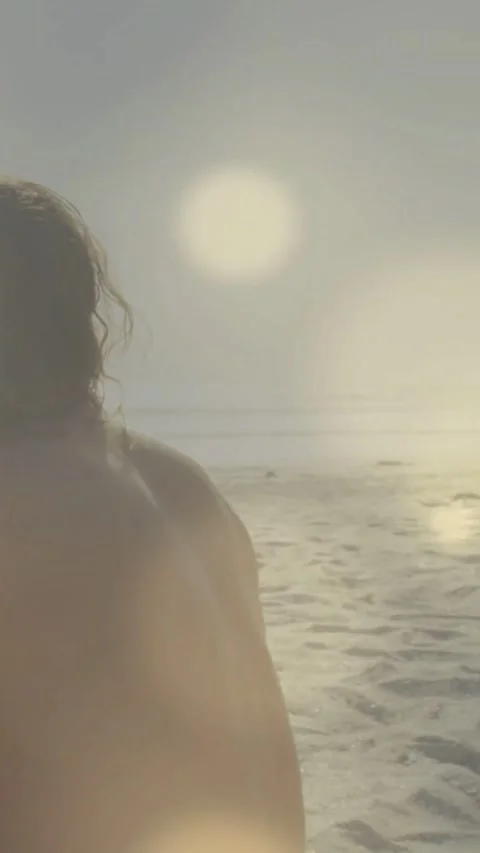 Vertical video: Low sun flare making cam panning in man moving showing wet back Video stock 334187484