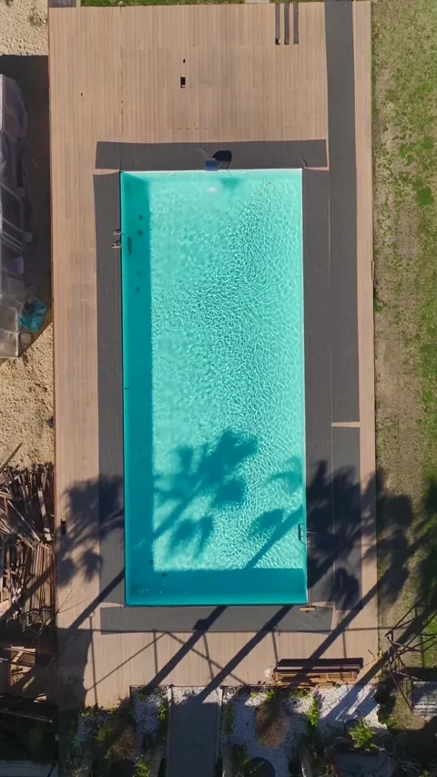 Vertical Video of a Luxurious Pool With Bright Blue Water Surrounded by a Scenic Stock Footage 300343651