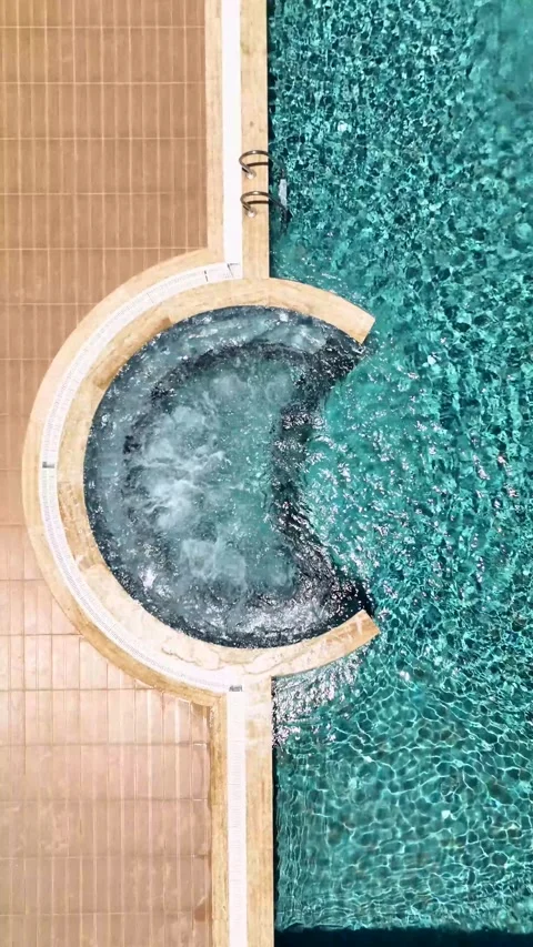 Vertical Video: Luxury Pool with Crystal-Clear Water and Jacuzzi Creating Gentle Stock Footage 297712705