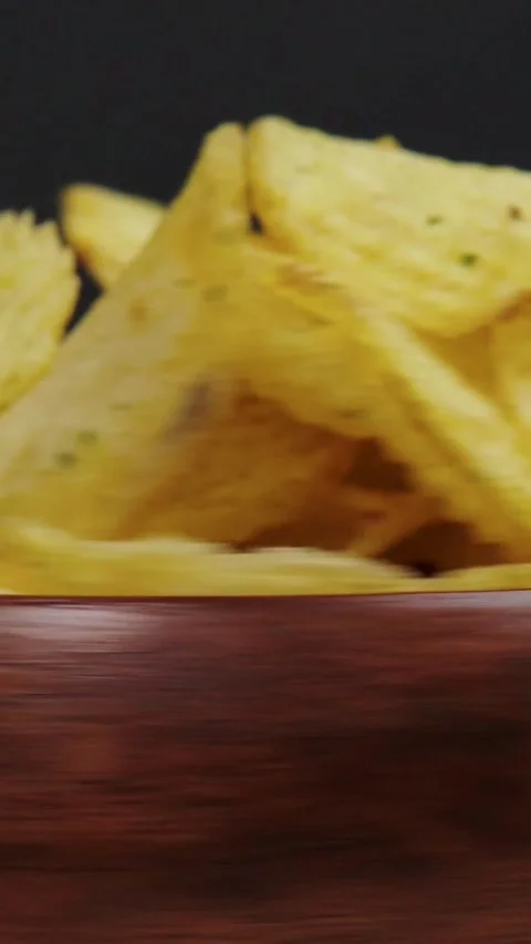 Vertical video macro shot of crispy corn tortilla chips piled in wooden bowl Stock Footage 345212131