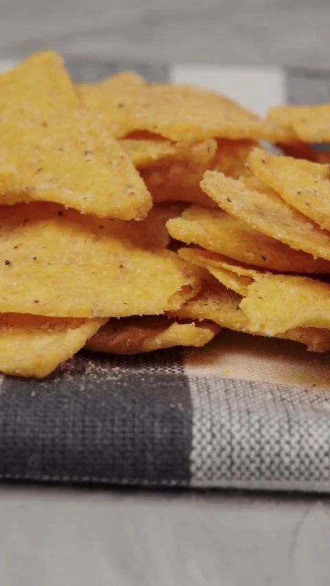 Vertical video macro shot of crispy corn tortilla chips piled in wooden bowl Stock Footage 345212352