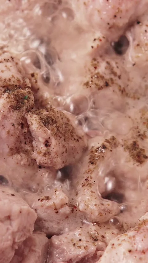 Vertical video macro shot of meat pieces stewing with spices in simmering sau Stock Footage 345972609