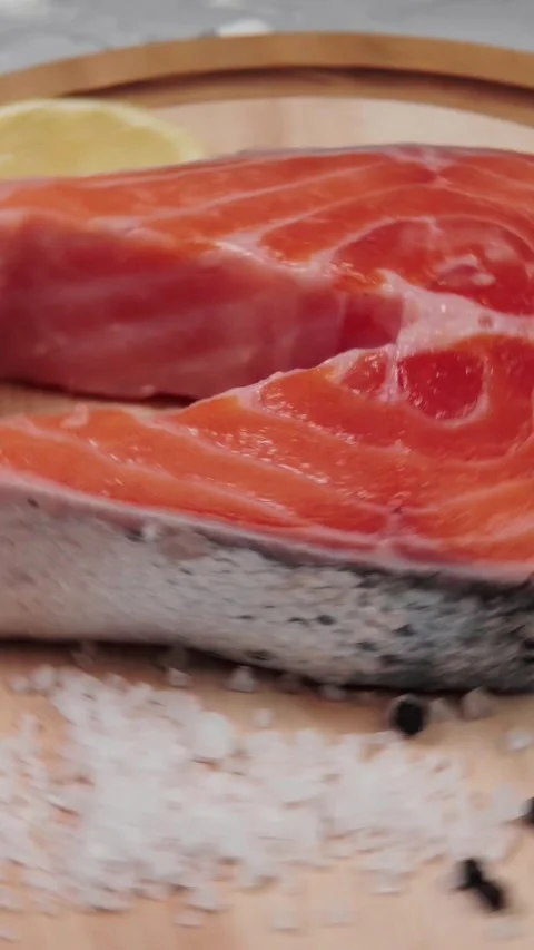 Vertical video macro shot of vibrant red raw salmon fish steak placed on a Video stock 345212151