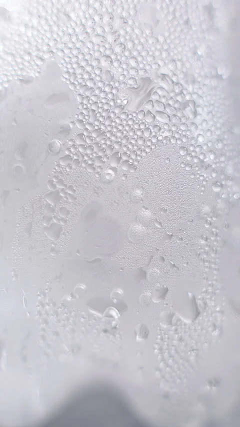 Vertical video. Macro View of Cold Plastic Bottle Slowly Rotating While Covered Stock Footage 339015169
