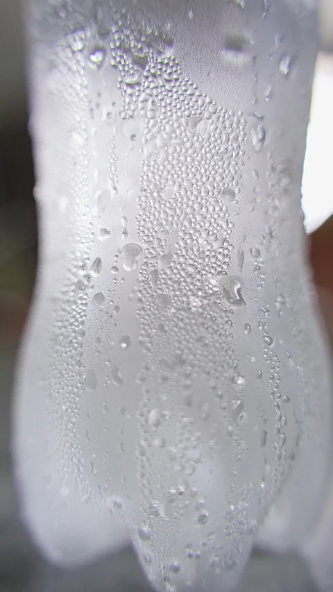 Vertical video. Macro View of Dense Condensation Covering Cold Plastic Bottle Su Stock Footage 339199944