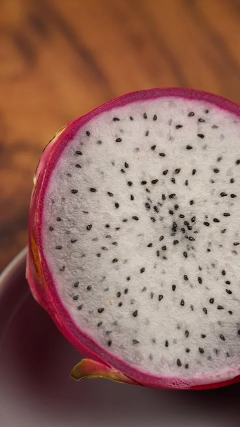 Vertical video, macro view of a dragon fruit cut in half showing its pulp Stock Footage 281035546
