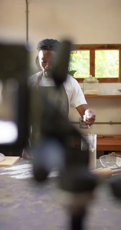 Vertical video: Male baker placing flour jar while rig blocking view, dusting Video stock 345220025