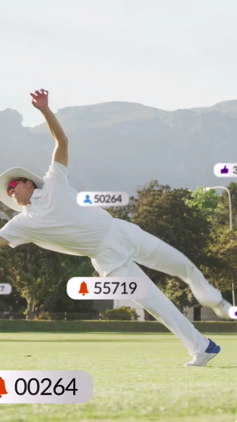 Vertical video: Male cricketer chasing incoming red ball, diving and rolling to Stock Footage 333913108