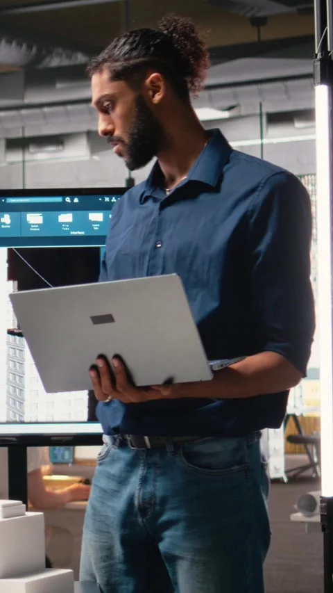 Vertical Video Male developer evaluating architectural 3D models and plans Stock Footage 316187472
