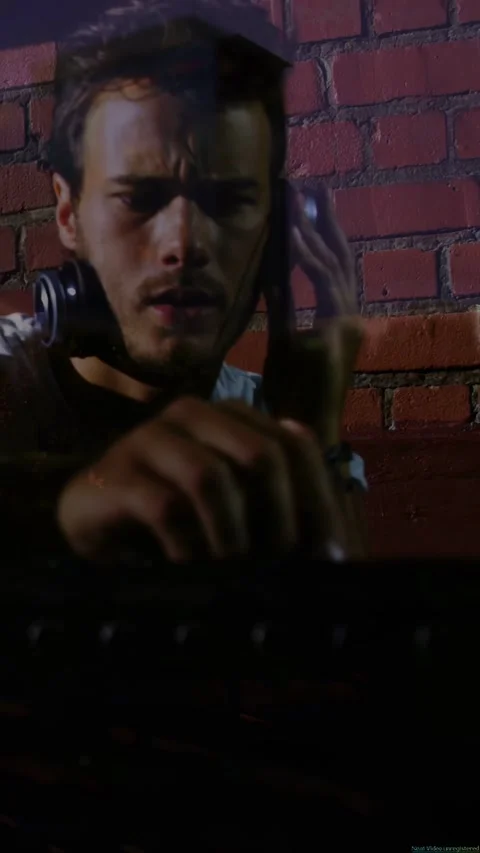 Vertical video: Male DJ hearing cue through headphones, adjusting mixer knobs to Stock-Footage 332806775