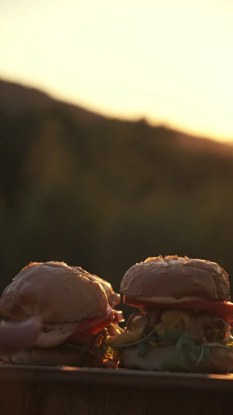 Vertical video of male hands puts burgers on background amazing sunset Stock Footage 286313593