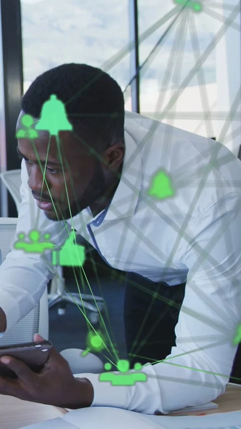 Vertical video: Male office worker leaning at desk, holding phone, checking Stock Footage 334377960