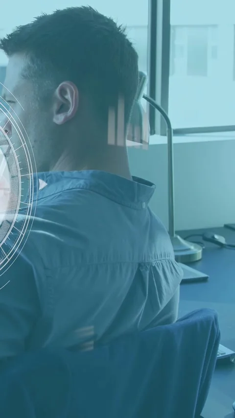 Vertical video: Male tech worker turning head at desk causing HUD showing screen Stock Footage 333480277