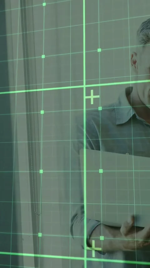 Vertical video: Man adjusting grip and tapping tablet at window, green HUD Stock Footage 331334271