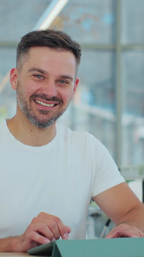 Vertical video. Man barista standing at counter in bar, looking at camera. Stockbeeldmateriaal 343770788
