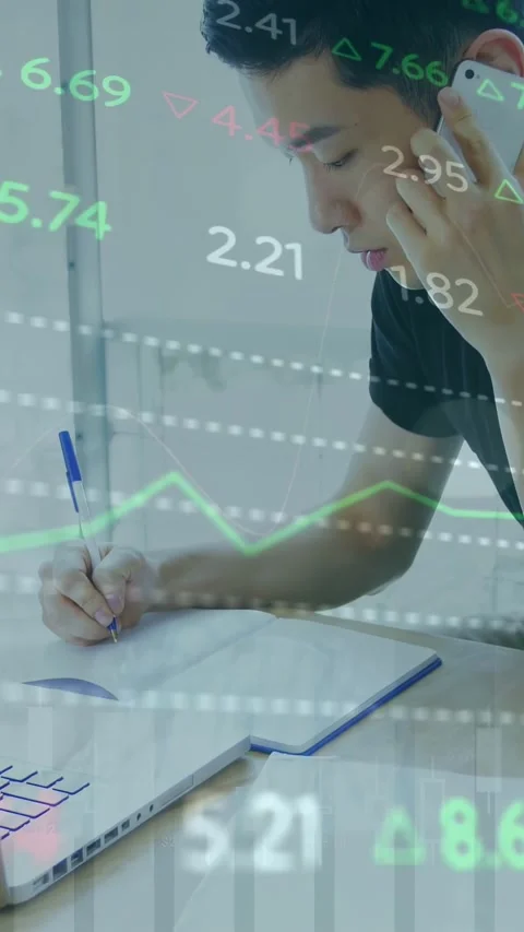 Vertical video: Man bringing phone to ear, noting market data by laptop while Stock Footage 335802867