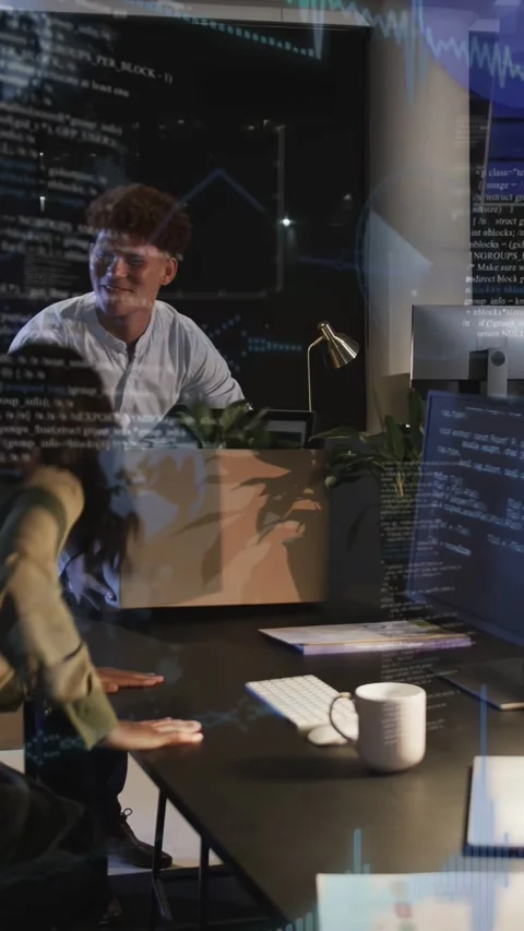Vertical video: Man bringing plant placing decor on IT desk, code screens lit, Stock Footage 333953996