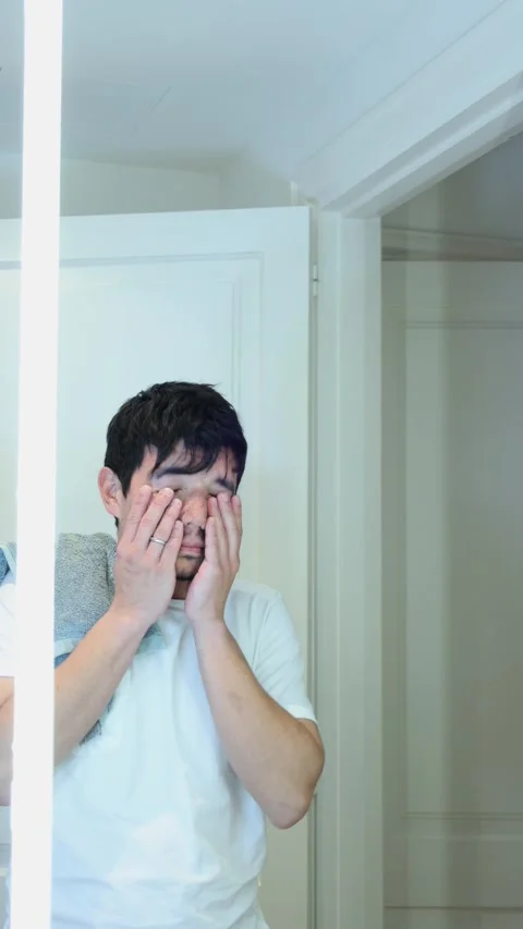 Vertical video of a man brushing his teeth in the bathroom of his house in .. Stock Footage 297666143