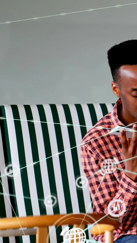 Vertical video: Man calling on white phone on bench, creating tech AR overlays Stock Footage 330359102