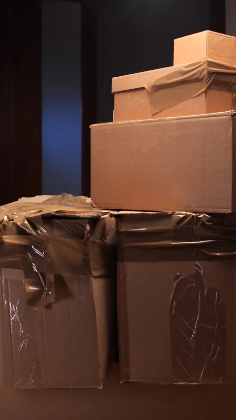 Vertical video Man carefully lifting moving boxes preparing for relocation Video stock 318981368