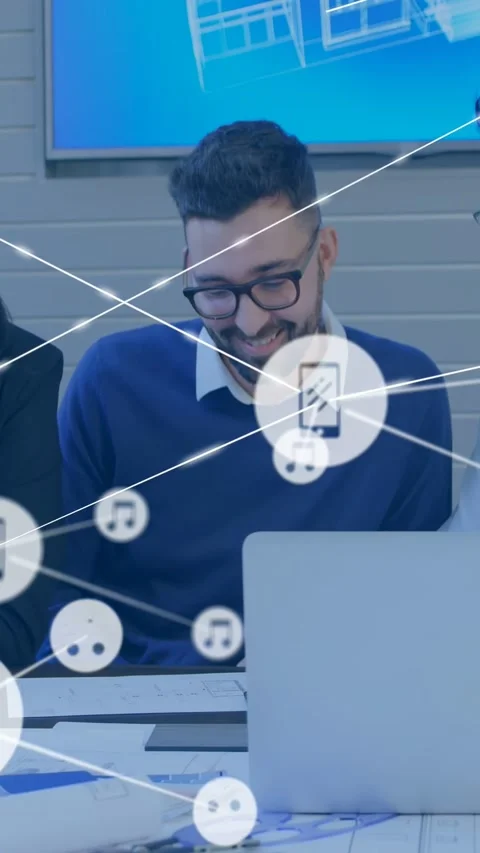 Vertical video: Man checking laptop, phone icon appearing over screen while team Stock Footage 333611059