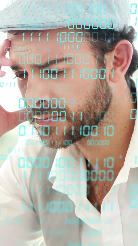 Vertical video: Man coding at tech desk, binary overlay on hands, pausing, Stock Footage 333289760
