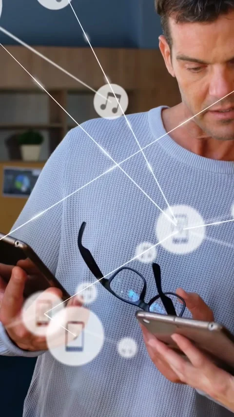 Vertical video: Man comparing phones holding glasses in tech lab, icons Stock Footage 334386609
