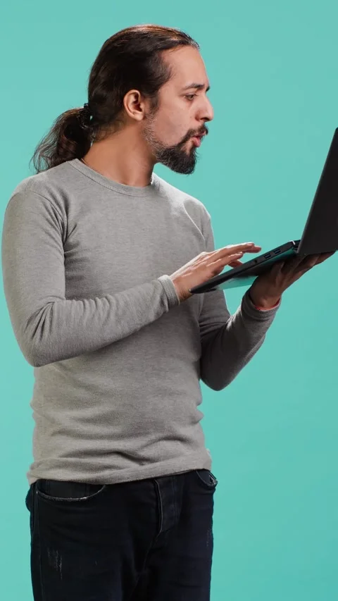 Vertical video Man composing email, typing on laptop keyboard, excited to log Stock Footage 314519188