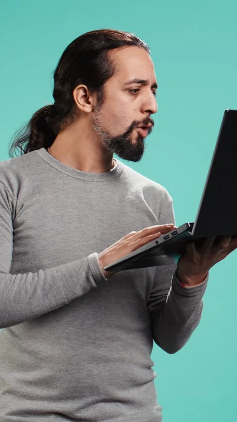 Vertical video Man composing email, typing on laptop keyboard, excited to log Stock Footage 314519304