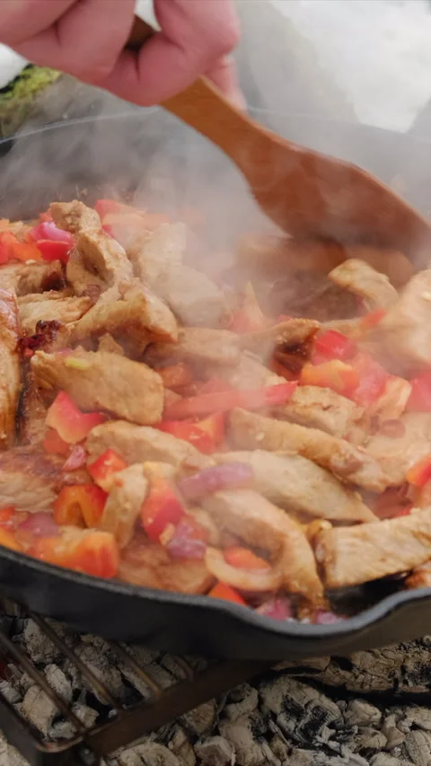 Vertical video of man cooking meat with peppers and spices languishing in pan Stock Footage 308705914