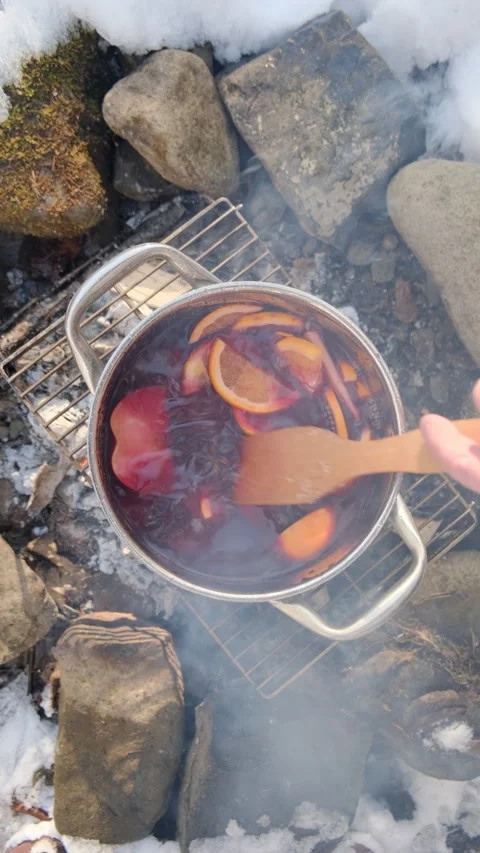 Vertical video of man cooking mulled wine on bonfire at winter time Stock Footage 300941060
