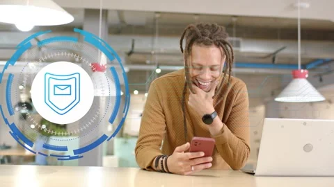 Vertical video: Man at desk checking phone causing teal shield overlay front Stock Footage 330206751